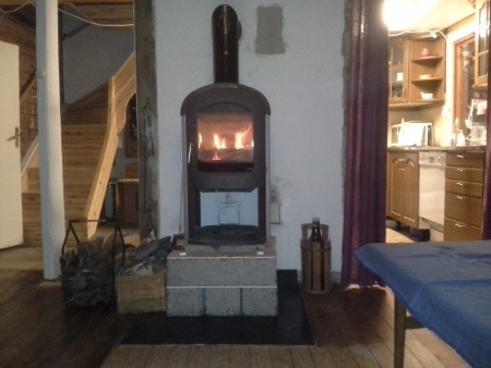 Jötul-kaminen, trappen till övervåningen och köksdelen sett från fåtöljen i vardagsrummet